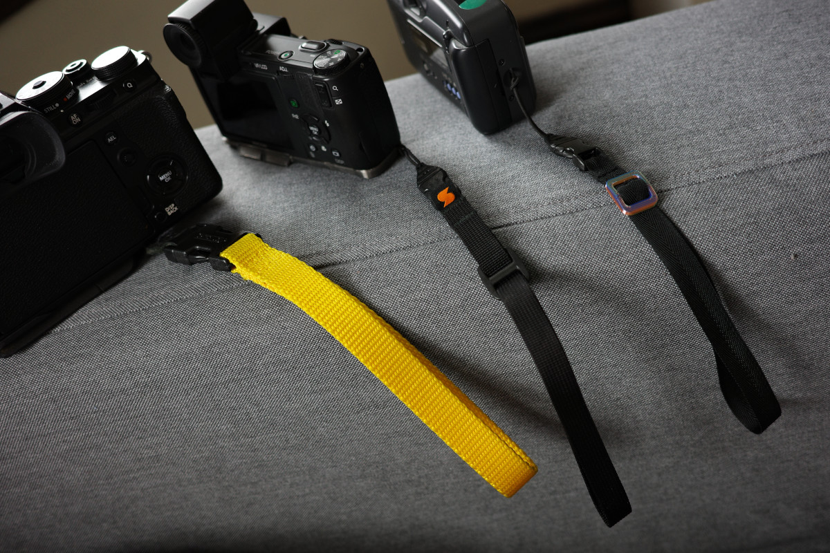 My X-T4 with its bright yellow, 1.5 inch wide nylon wrist strap, my Ricoh GX200 with the discontinued Simplr.US half inch wide wrist strap, and a Fujifilm Cardia Mini Everyday OP wearing my new DIY half inch nylon wrist strap.
